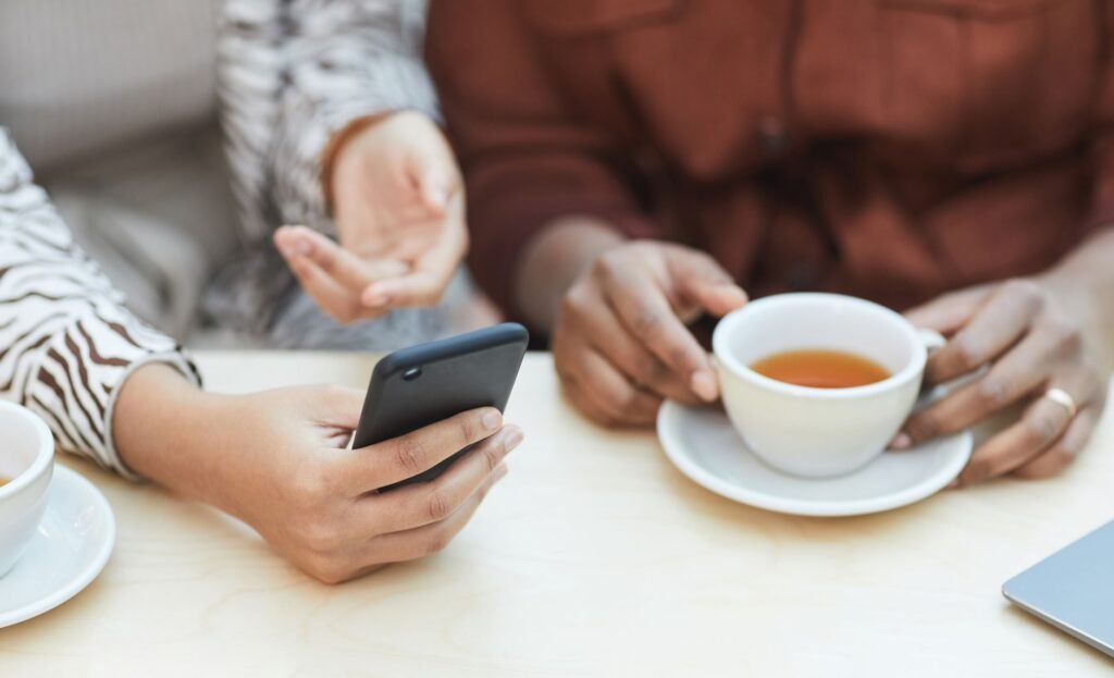 Smartphone posé sur une table de café avec une rue française floue en arrière-plan