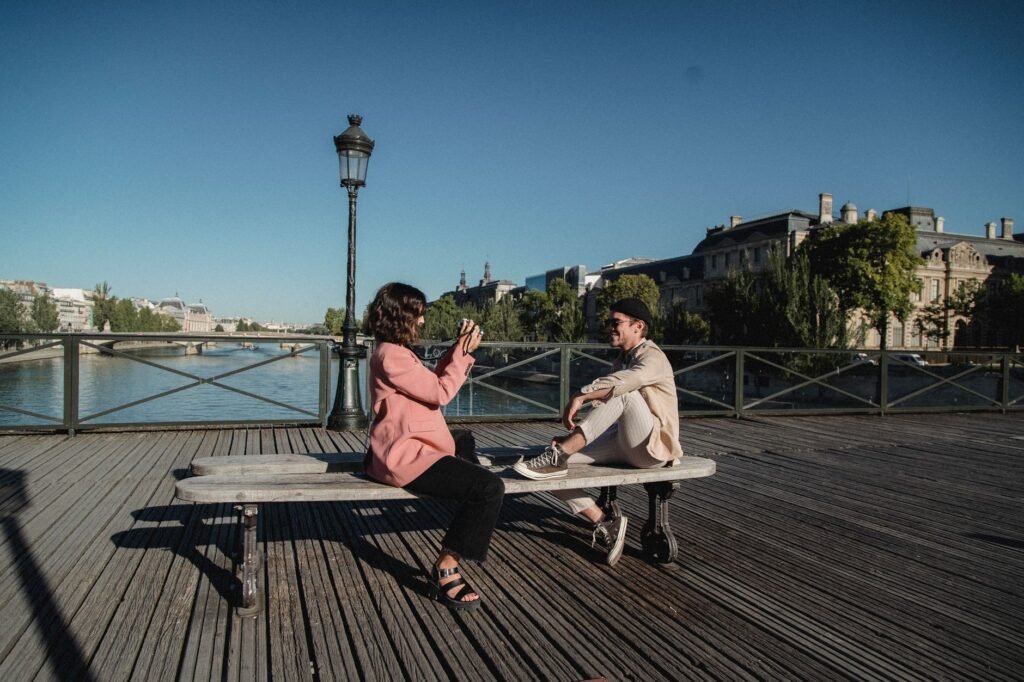 Deux personnes conversant calmement à une table de café parisien, illustrant une conversation respectueuse