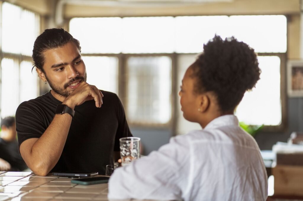 Deux adultes discutant calmement à une table de café en Guadeloupe