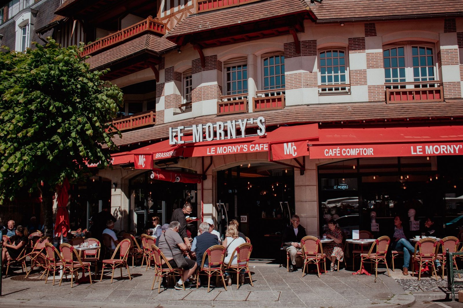 Rue calme de Caen avec façades en pierre et café discret, Normandie