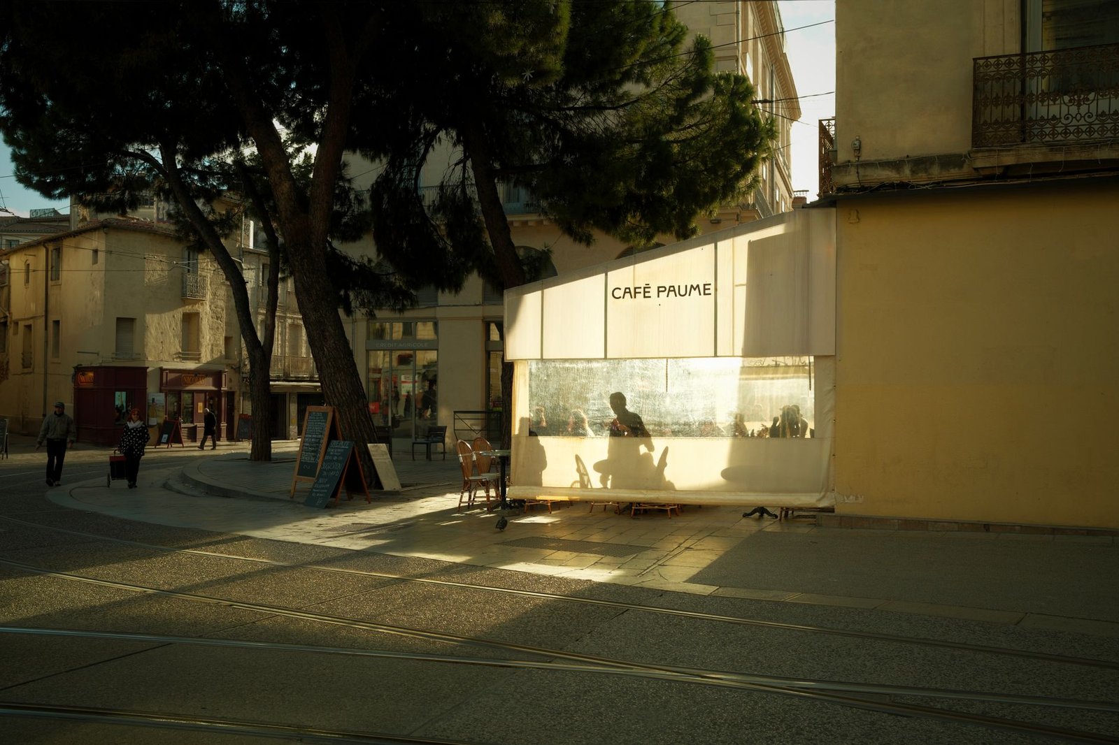 Terrasse de café calme au crépuscule dans une ville française, ambiance discrète propice à la conversation