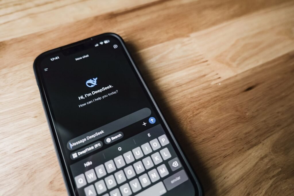 Smartphone sur une table en bois près d'une fenêtre, évoquant une communication claire avant une réservation.