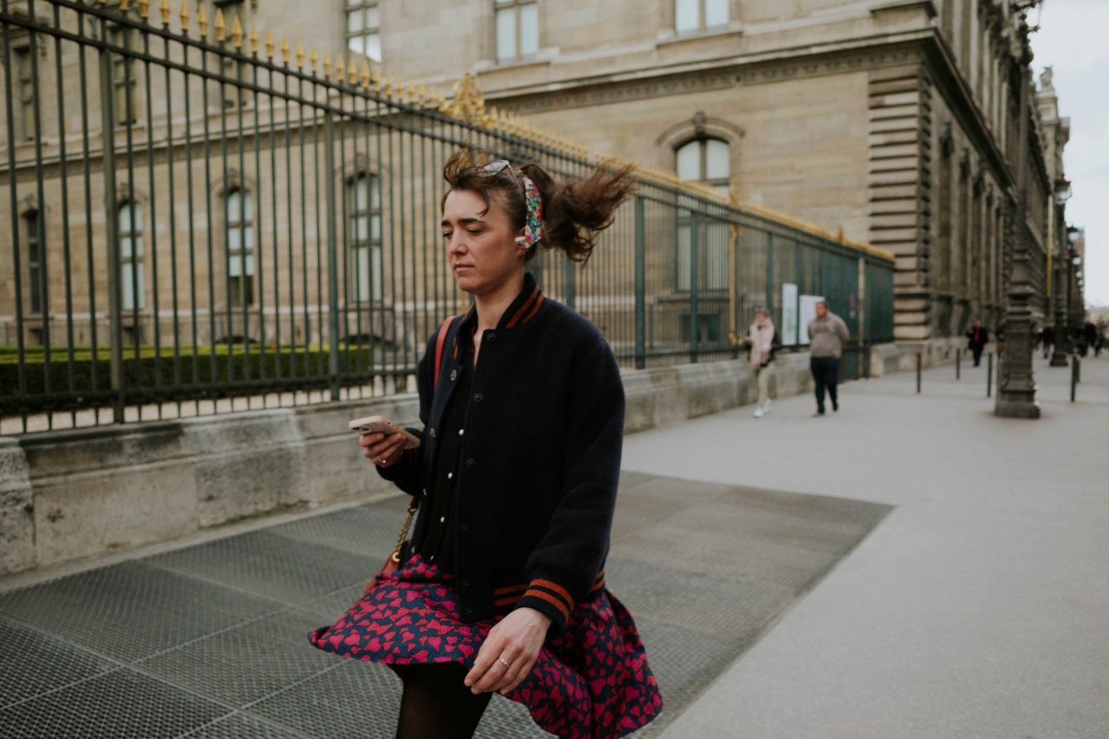 Personne consultant son téléphone dans une rue de Paris au crépuscule