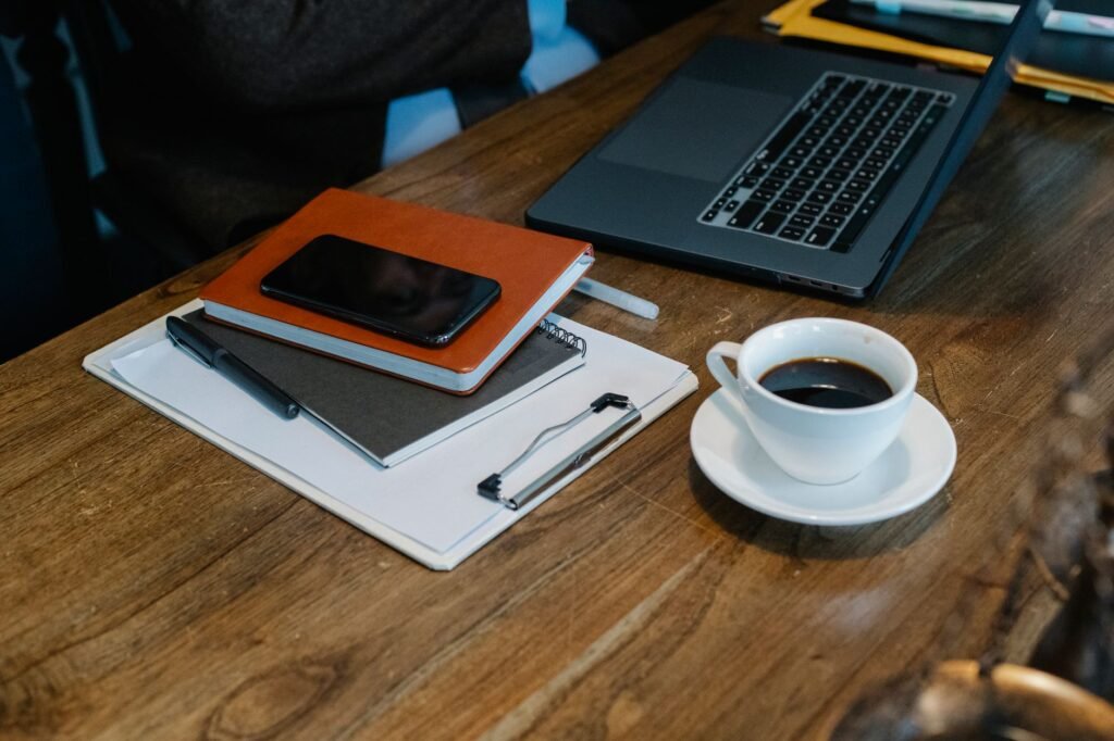 Smartphone posé sur une table de café à Toulouse avec carnet et tasse, écran illisible