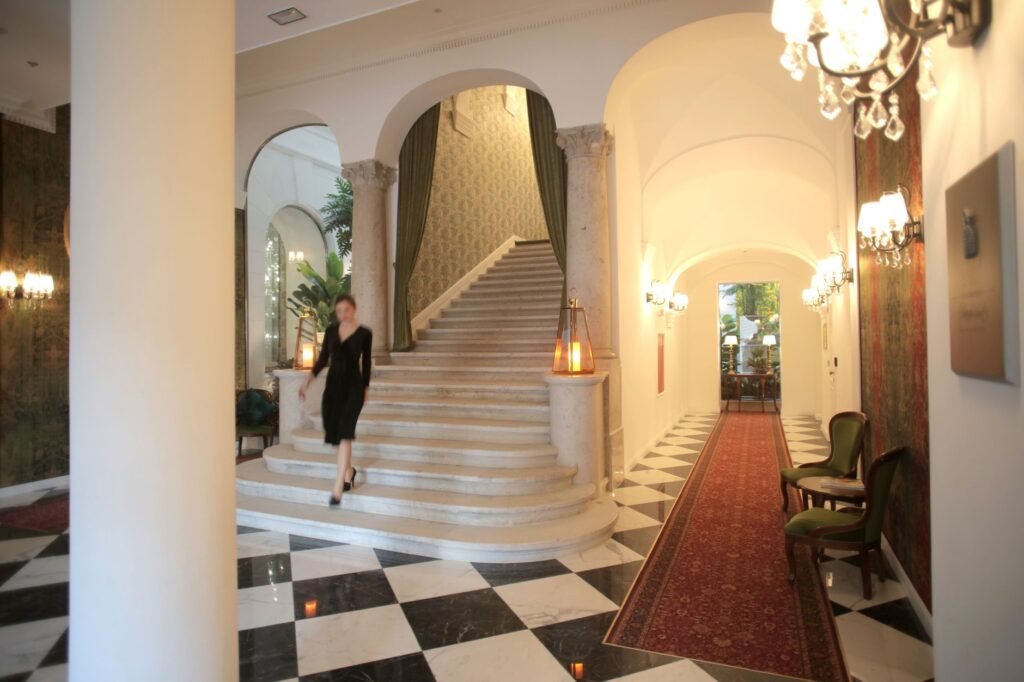 Lobby d’hôtel discret à Cannes en début de soirée, éclairage chaleureux