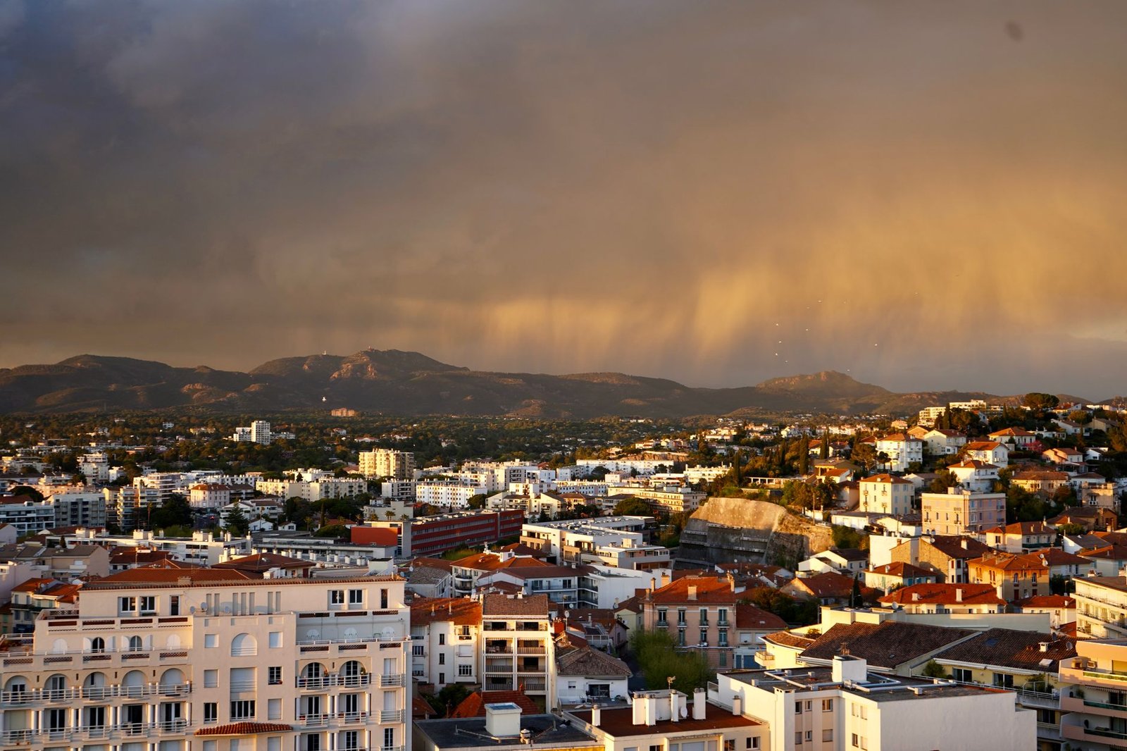 Rue calme de Cannes au coucher du soleil avec façades méditerranéennes et terrasse de café