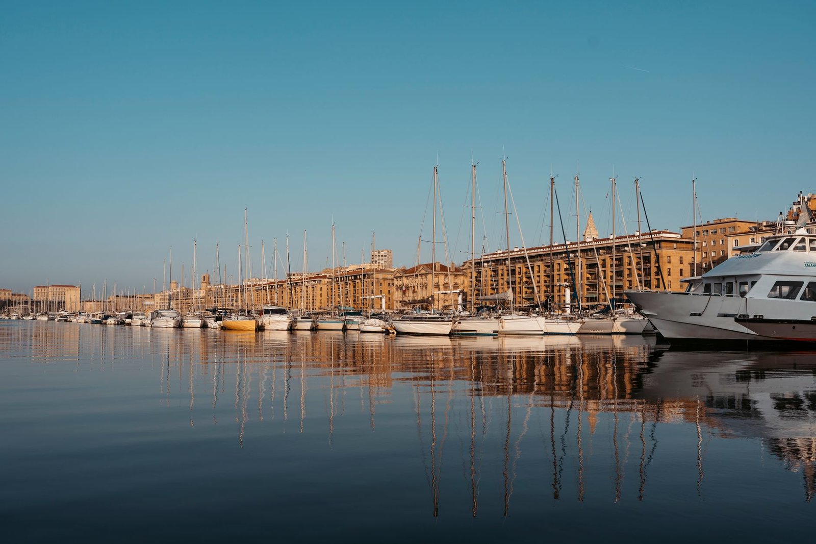Le Vieux-Port de Marseille au coucher du soleil, quais et bateaux dans une lumière dorée