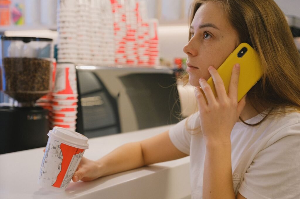Personne consultant son téléphone dans un café en soirée pour préparer une sortie