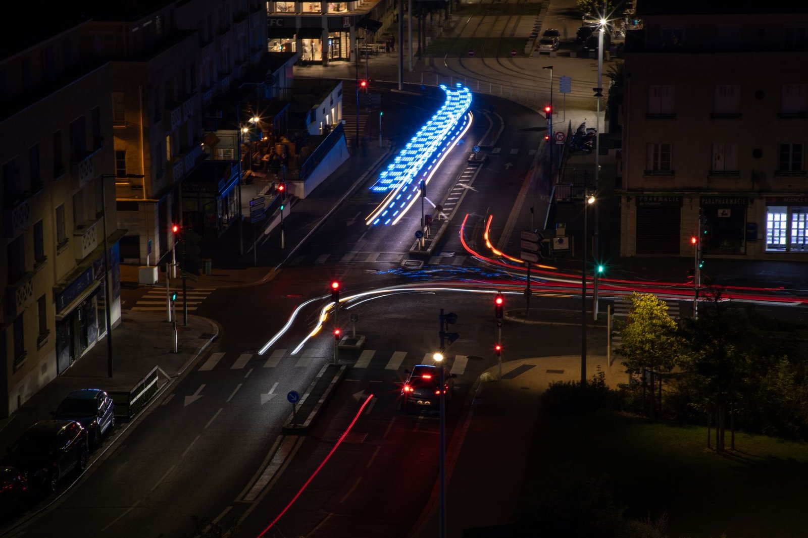 Rue piétonne animée de nuit dans un centre-ville français, lumières chaudes et ambiance de soirée adulte discrète.