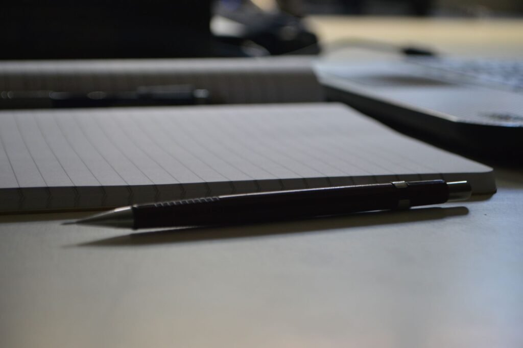 Carnet ouvert et stylo sur une table, évoquant la préparation d'un premier contact courtois.
