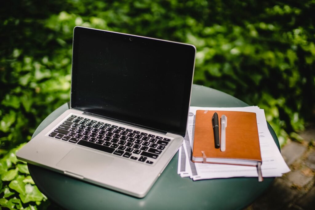 Ordinateur portable, carnet et stylo sur une table, pour illustrer la lecture attentive d'annonces