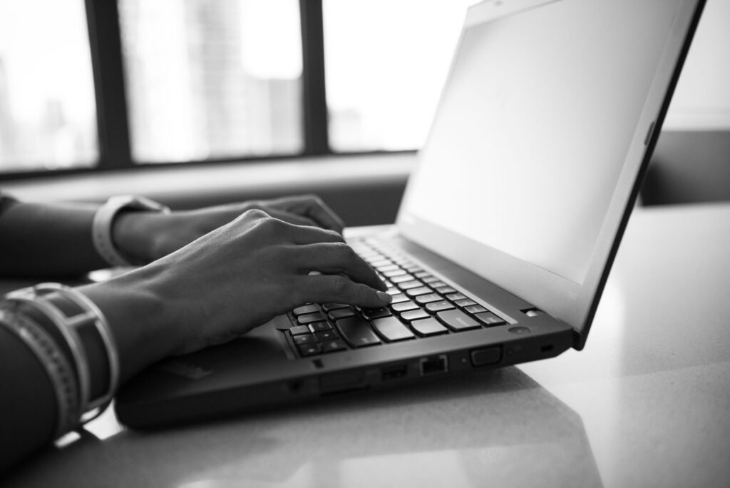 Ordinateur portable ouvert près d'une fenêtre, lecture d'un annuaire en ligne pour Montpellier