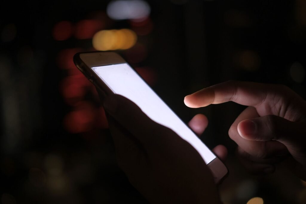 Personne consultant une messagerie sur smartphone avant un premier contact pour une rencontre adulte