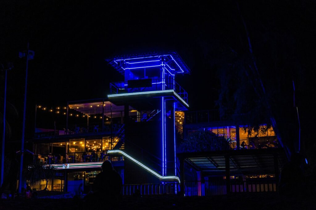 Terrasse de restaurant éclairée la nuit en Guadeloupe, tables vides et plantes tropicales