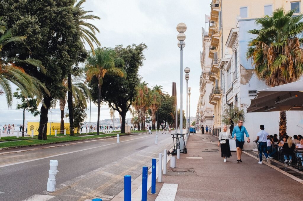 Couple élégant marchant sur la promenade des Anglais à Nice le soir