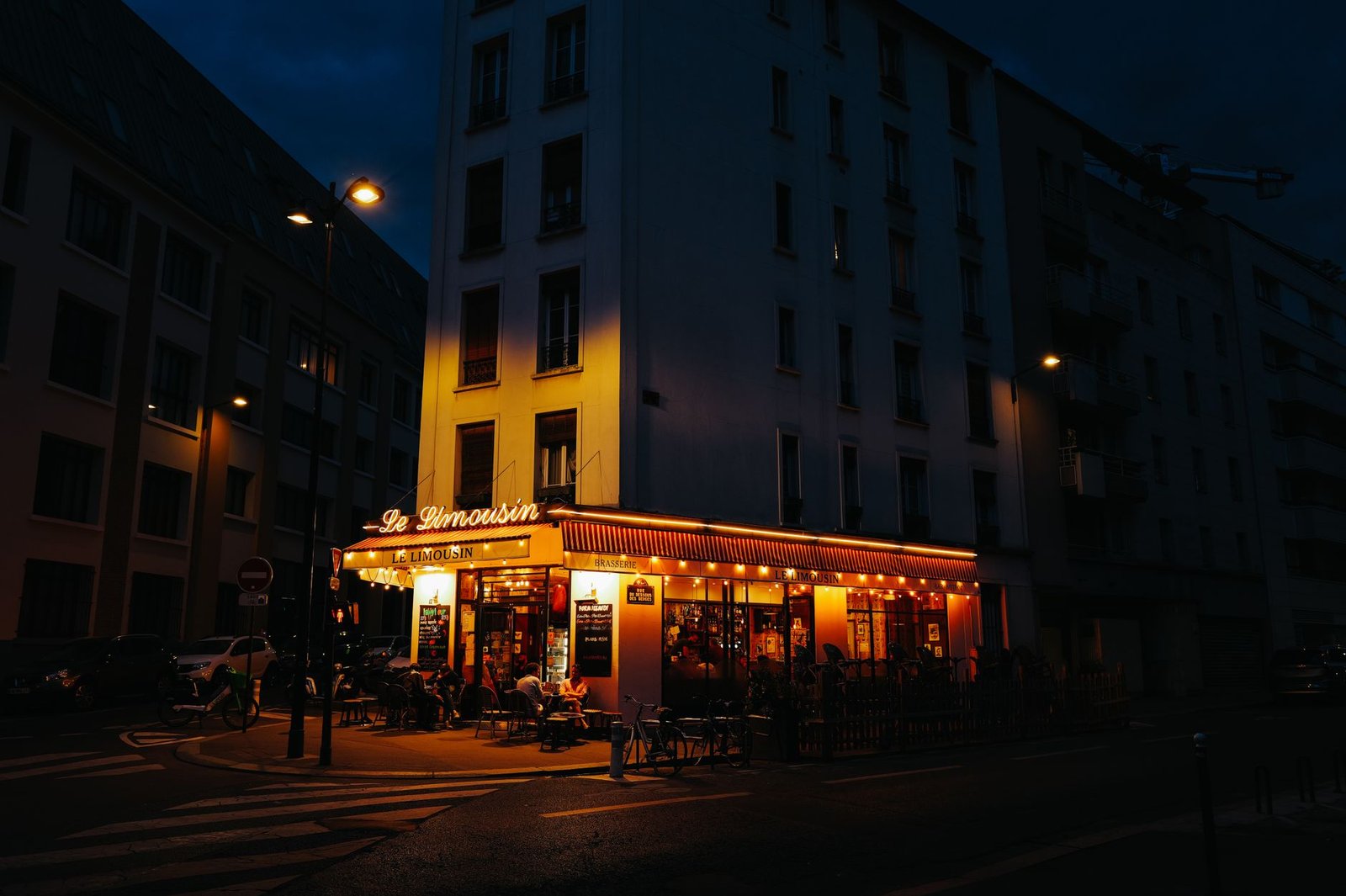 Rue calme de Tarbes au crépuscule avec lumières de café et pavés humides